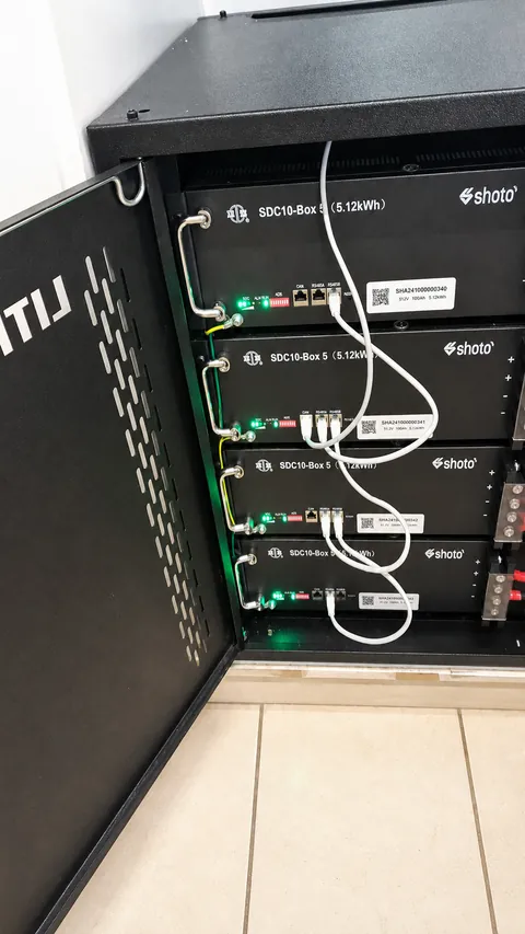 Black cabinet with four stacked rack-mounted batteries