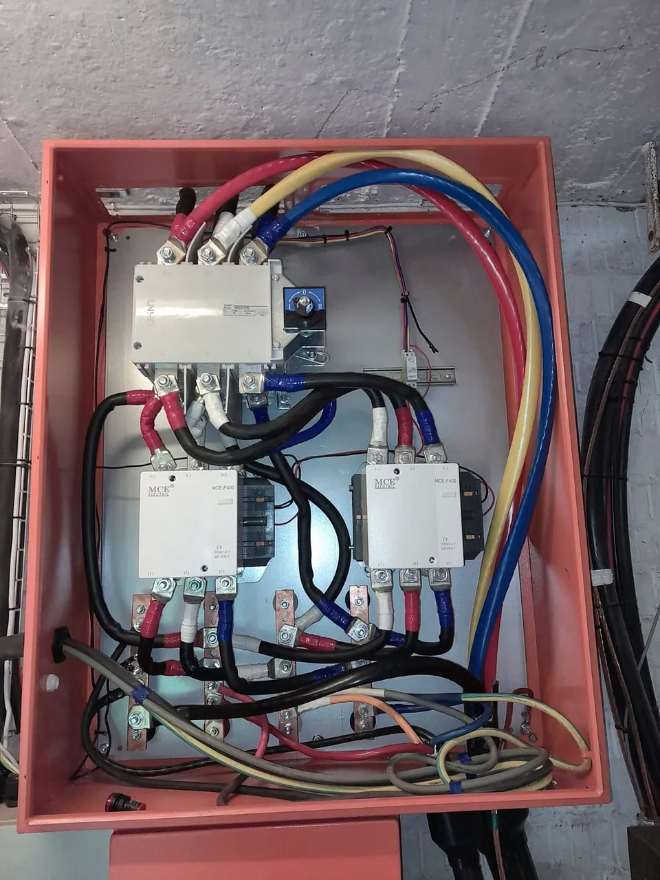 Enclosure with a changeover switch, two large contactors, busbars and heavy cabling